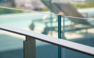 closeup modern flat stainless railing and glass wall on outdoor building.