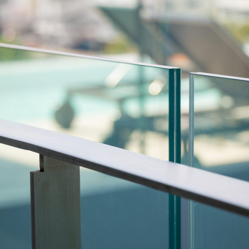 closeup modern flat stainless railing and glass wall on outdoor building.