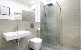 Interior shot of a brand new modern bathroom with a walk-in shower.
