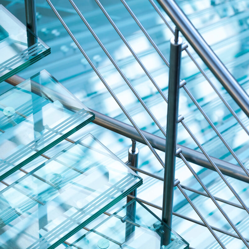 Modern interior abstract fragment with steel railings and stairs made of glass